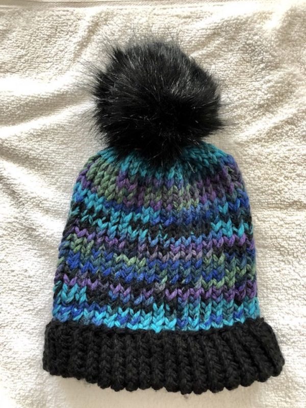 Image of a Peacock colours and black knit hat